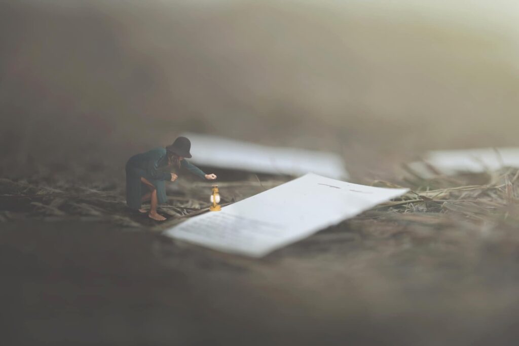 A tiny woman holds a lantern up to pages of a book.